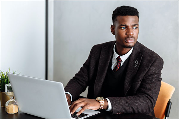 Serious businessman sitting with laptop
