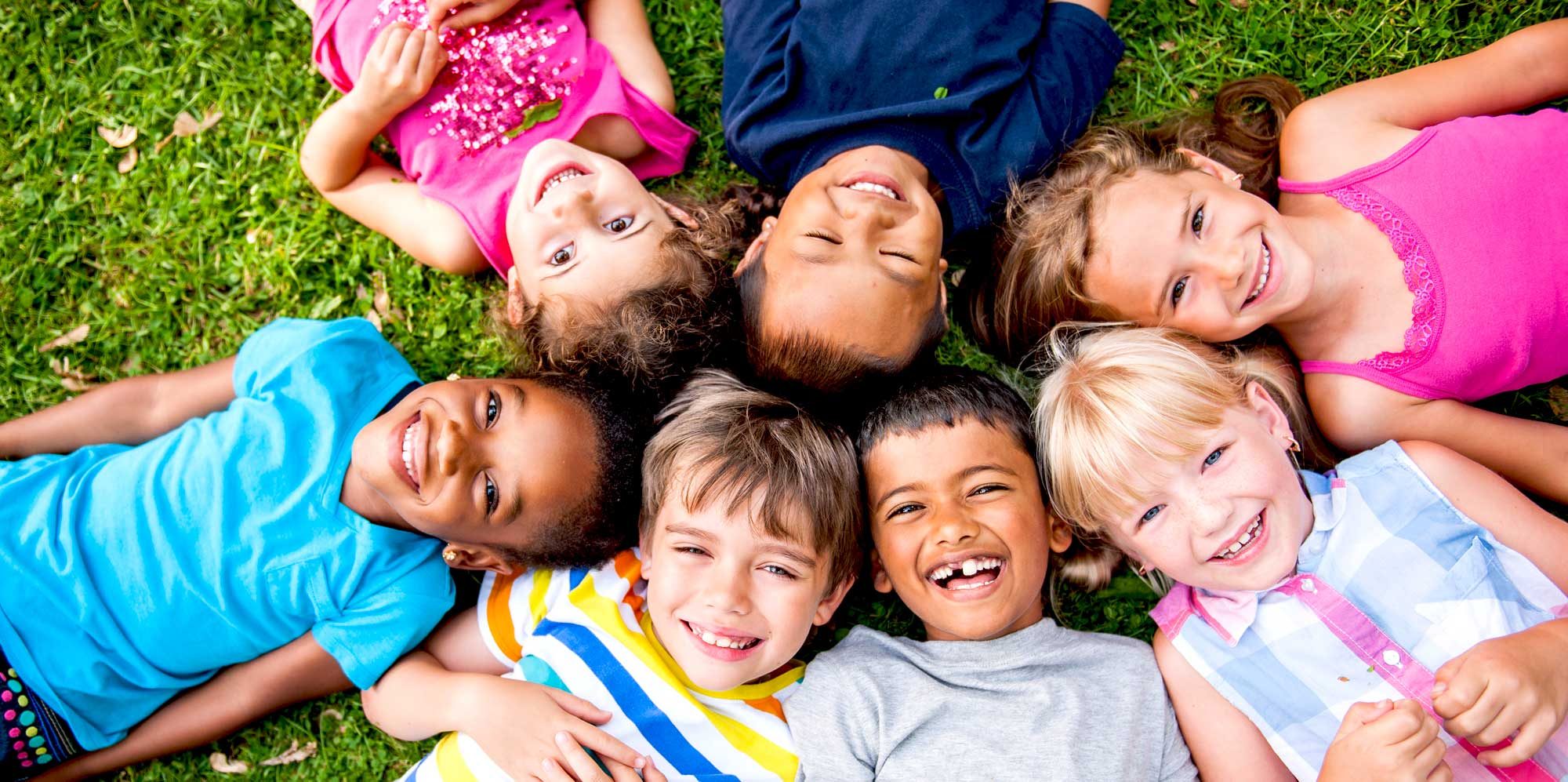 Diverse children lying on the ground in a circle