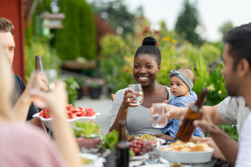 African American woman holding a baby at a outdoor dinner