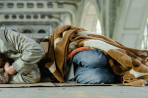 Homeless person sleeping under bridge
