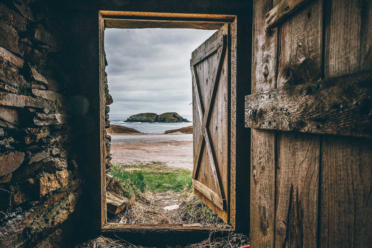 Brown wooden shed door open to ocean view