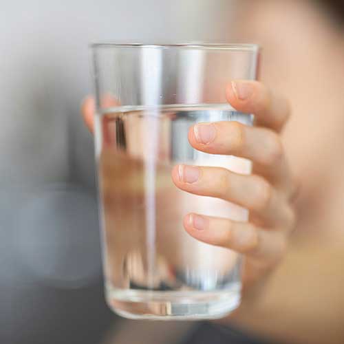Close up of hand holding a glass of water