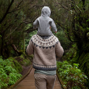 Father walking with son on shoulders.